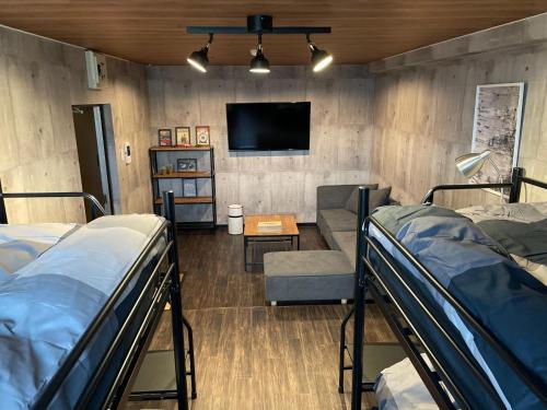 雾岛市InnCocoSumu？ - Vacation STAY 03969v的客房设有双层床、电视和沙发。