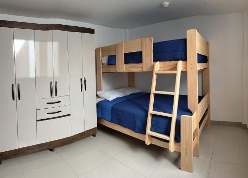 皮斯科Airbnb Paracas Inn的一间卧室设有两张双层床和梯子