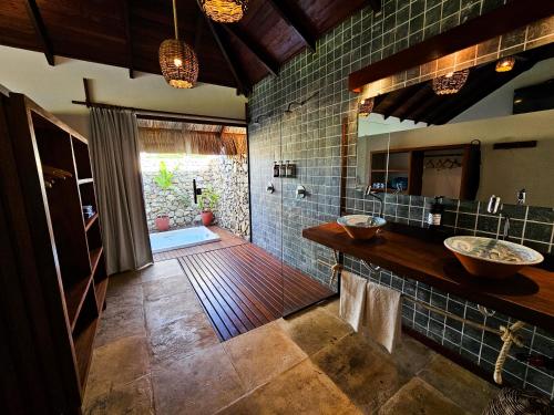 圣米格尔-杜戈斯托苏Kauli Seadi Beach Hotel的一间带两个盥洗盆和大镜子的浴室