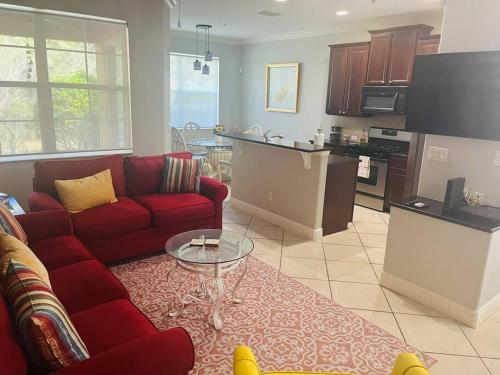 基西米Theme Park Gateway!的一间带红色沙发的客厅和一间厨房