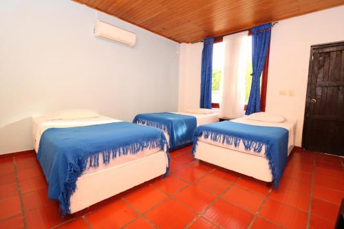 亨达Hotel y Parque Acuatico Agua Sol Alegria的蓝色和白色的客房内的三张床