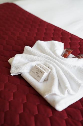 昆比恩Hotel Queanbeyan Canberra的红色床铺上方的白色毯子