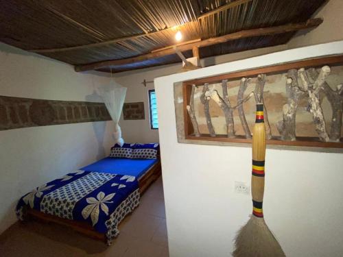 Lodge au paradis fleuri的一间设有一张床的房间和墙上的棒球棒