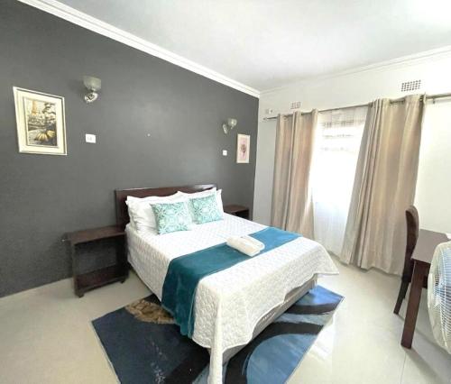 卢萨卡Busisiwe's RM Home的一间卧室配有一张带蓝白色毯子的床