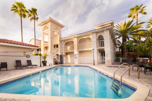 圣奥古斯丁海滩Best Western Seaside Inn的棕榈树屋前的游泳池