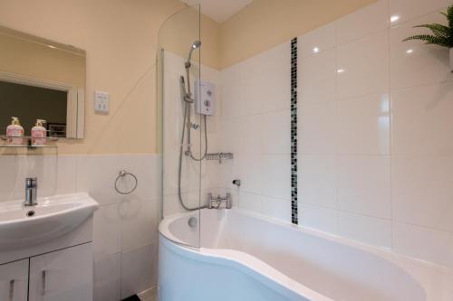 卡迪夫Seaview Cottage的白色的浴室设有浴缸和水槽。