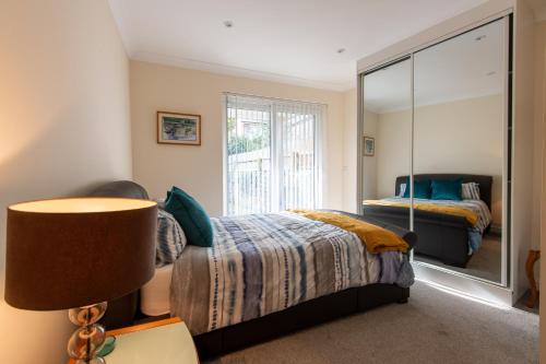 卡迪夫Seaview Cottage的一间卧室配有一张床和一面大镜子
