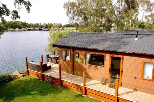 塔特舍尔Fable Lodge Tattershall Lakes - luxury lakeside lodge with hot tub的湖畔的大型小木屋