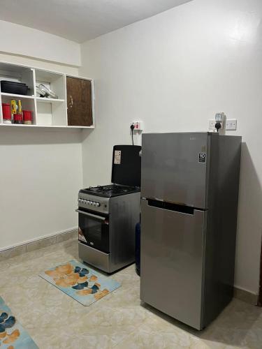 KerichoSerene cozy homes Kericho的厨房配有炉灶和不锈钢冰箱。
