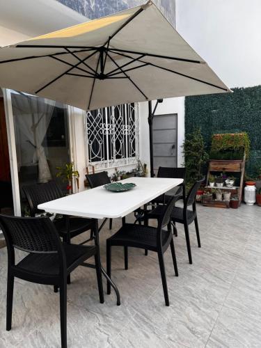 曼塔Mar y Tierra的一张带椅子的白色桌子和一把雨伞