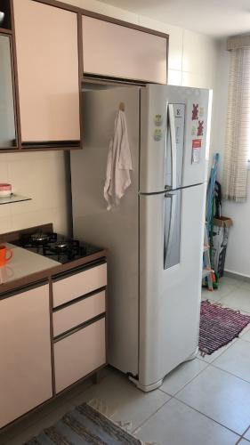 波苏斯-迪卡尔达斯Apartamento encantandor-perto centro e shopping的厨房配有冰箱和炉灶。