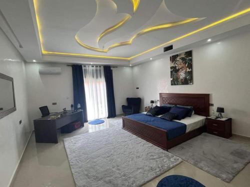 马拉喀什Villa Anis- VacayX - MARRAKECH的一间大卧室,配有一张床和天花板及绘画