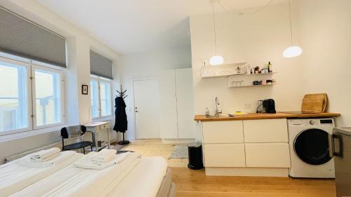 哥本哈根ApartmentInCopenhagen Apartment 1539的厨房配有白色橱柜、水槽和炉灶。