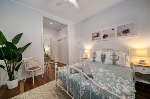 拜伦湾A Perfect Stay - A Summer Cottage的一间卧室配有床、植物和镜子