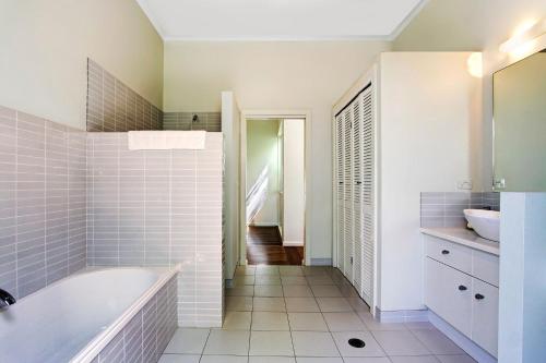 拜伦湾A Perfect Stay - A Summer Cottage的带浴缸和盥洗盆的浴室
