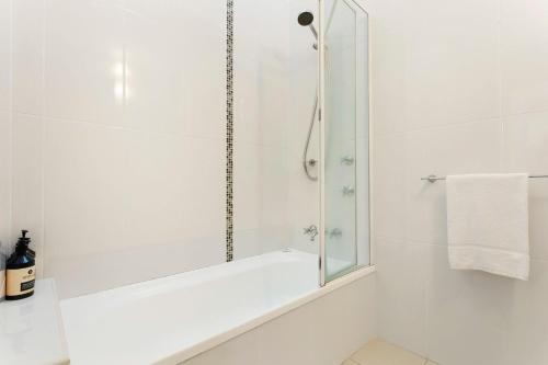 拜伦湾A Perfect Stay - Beach House at Tallows的白色的浴室设有淋浴和镜子