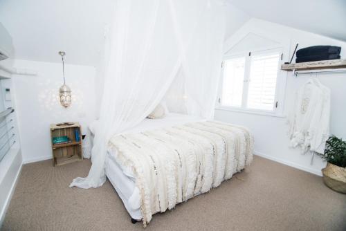 拜伦湾A Perfect Stay - Cactus Rose Villa的白色卧室配有一张带天蓬的床