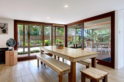 拜伦湾A Perfect Stay - Jimmys Beach House的一间带木桌和长凳的用餐室
