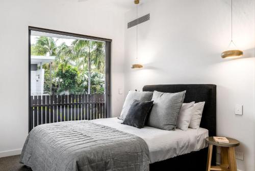 拜伦湾A Perfect Stay - KoKos Beach House 2的一间卧室设有一张床和一个大窗户