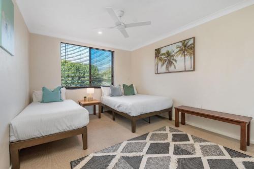 拜伦湾A Perfect Stay - Lisas on Lawson的客房设有两张床、一张桌子和一扇窗户。
