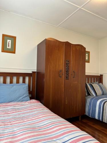 GrassyTwo Twenty Two Farm Stay的一间卧室设有两张床和木制橱柜