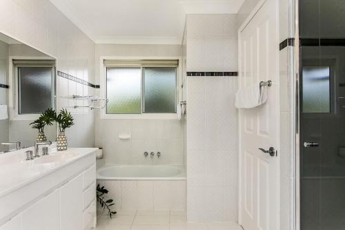 班加洛A Perfect Stay - Tradewinds 4的白色的浴室设有浴缸和水槽。