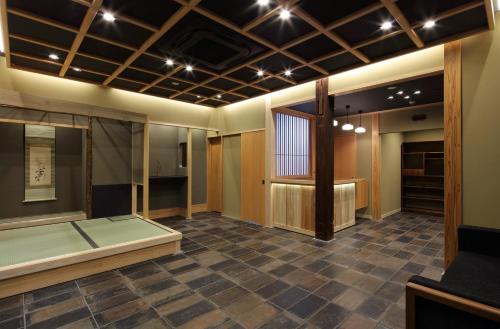 大阪Ryokan Suzuran Tengachaya的大客房设有大窗户 和瓷砖地板。