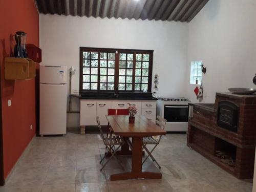 圣罗克Tranquilidade e conforto na floresta - Rota do Vinho的厨房配有木桌和冰箱。