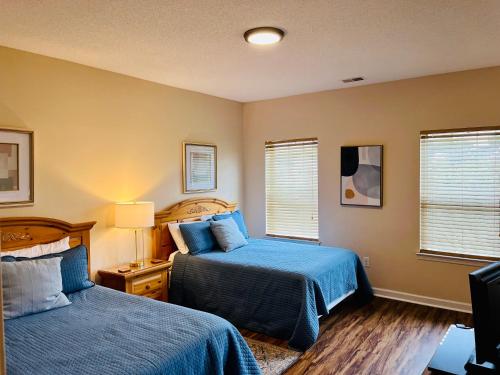 默特尔比奇Two-Bedroom Vacation Condo的一间卧室设有两张床和两个窗户。