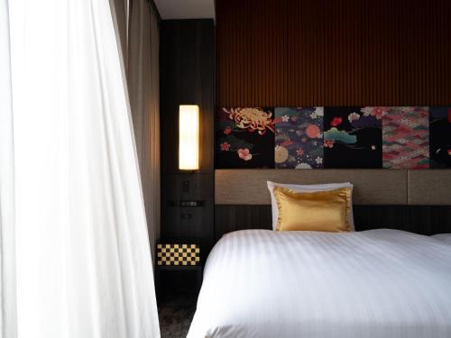 金泽Mitsui Garden Hotel Kanazawa的卧室设有白色的床和大窗户