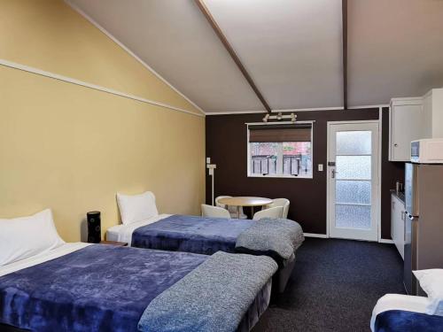 ParakaiParakai Geothermal Motel的酒店客房设有两张床和一张桌子。