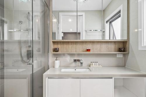 墨尔本Boutique Stays - Edinburgh Place的白色的浴室设有水槽和淋浴。