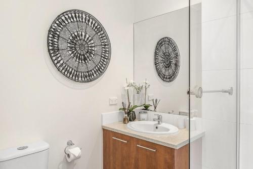 MentoneBoutique Stays - The Richardson的一间带水槽、卫生间和镜子的浴室