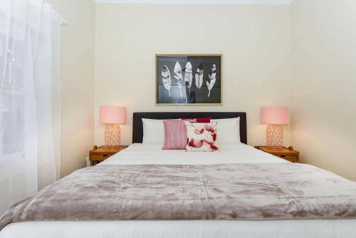 墨尔本Boutique Stays - Carlton Terrace的一间卧室配有一张大床和两盏灯
