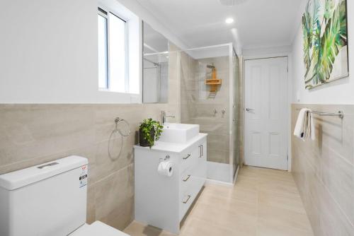 墨尔本Boutique Stays - Carlton Terrace的白色的浴室设有水槽和淋浴。