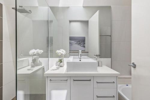 墨尔本Boutique Stays - Port Haven的白色的浴室设有水槽和镜子