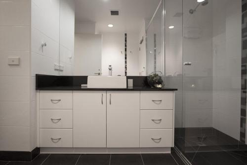 墨尔本Boutique Stays - Wellington Mews的白色的浴室设有水槽和淋浴。