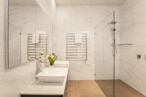 墨尔本Boutique Stays - Central Park的白色的浴室设有水槽和淋浴。