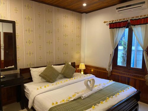 琅勃拉邦金莲花广场宾馆的一间卧室设有两张床和窗户。