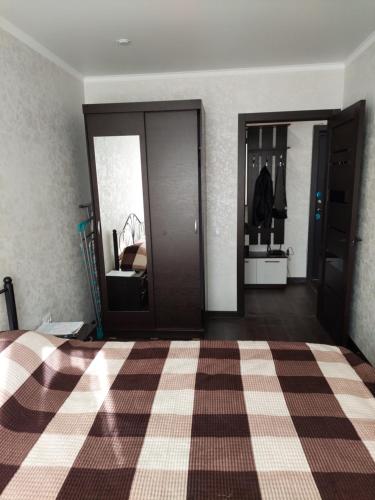 卡拉甘达Квартира的一间卧室配有一张带 ⁇ 架地板的床
