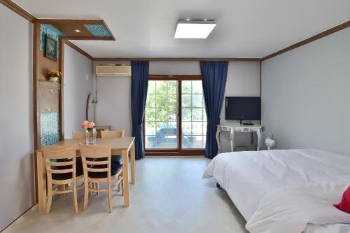 襄阳郡Yangyang Pulbit Pension的一间卧室配有一张床、一张桌子和一张书桌