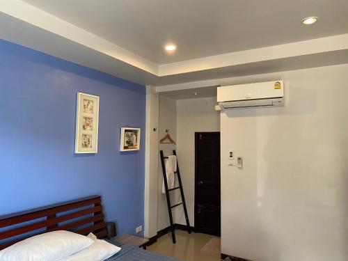 玛哈沙拉堪กัญญ่า เพลส KANYA的一间卧室设有一张床和蓝色的墙壁