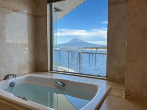 沼津Awashima Hotel的带浴缸的浴室和大窗户