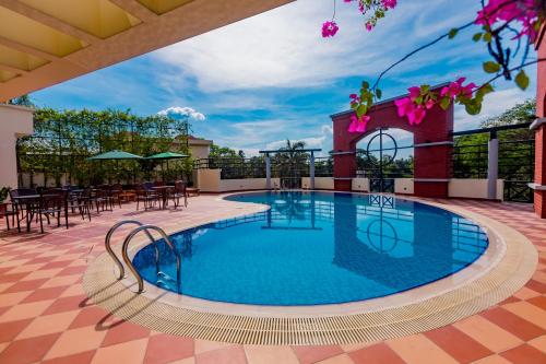 巴里沙尔Hotel Grand Park Barishal的一座带桌椅的建筑屋顶上的游泳池