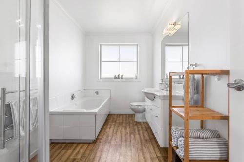 瓦纳卡It's Easy! Space and comfort的白色的浴室设有浴缸、盥洗盆和卫生间。