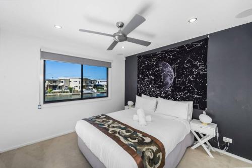 黄金海岸Luxury Modern Waterfront House的一间卧室设有一张大床和一个窗户。