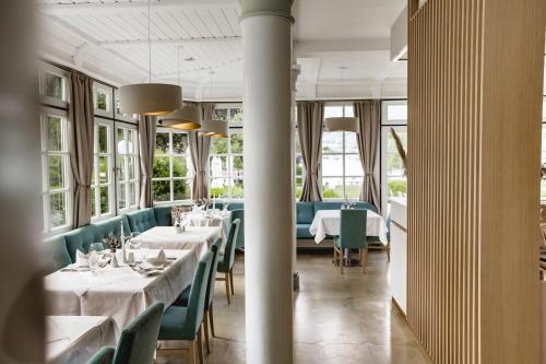 施特罗布尔Hotel Brandauers Villen Superior的餐厅设有白色的桌子和绿色的椅子