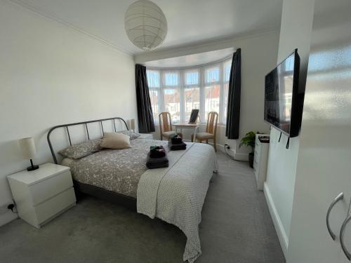 Harrow on the HillDouble Bedroom with TV in Sudbury Hill Wembley - 10 mins from Wembley Stadium的一间卧室配有一张床和一台平面电视