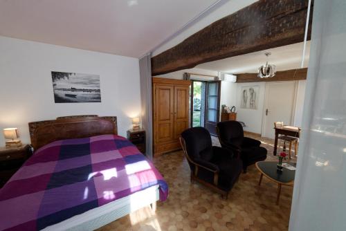 Saint-Dyé-sur-LoireLa Boisselée的一间卧室配有一张紫色的床和两把椅子