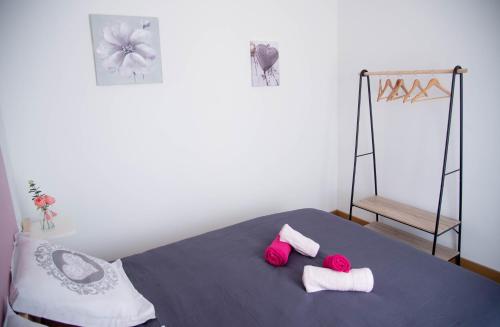 MusLes Brézines - Maison Clim Terrasse Plancha au coeur de Mus 3 Etoiles - MaisoncarréeConciergerie的一间卧室配有一张带两个粉红色枕头的床